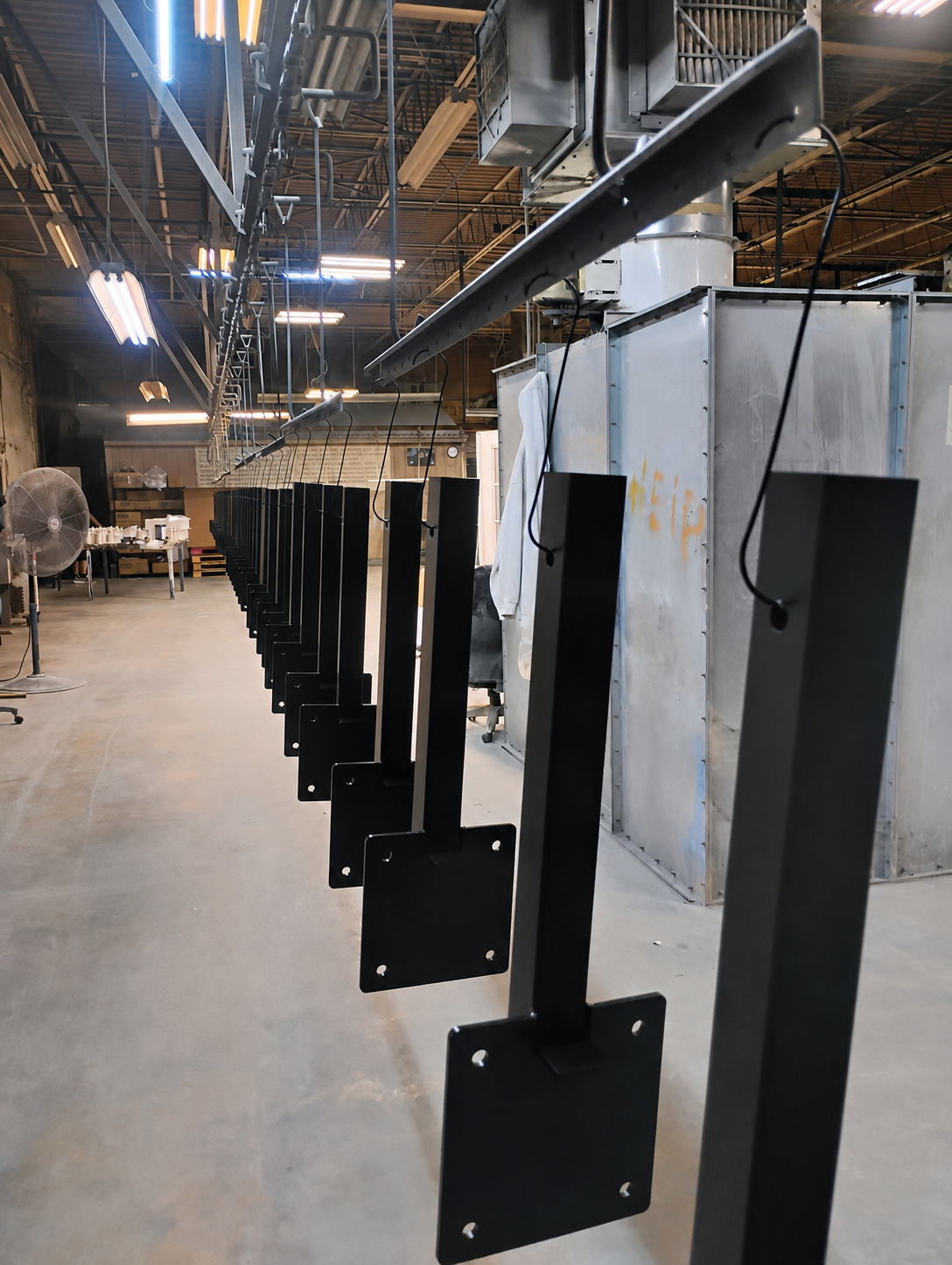 Black powder-coated GenCaddy mounting components on the production line